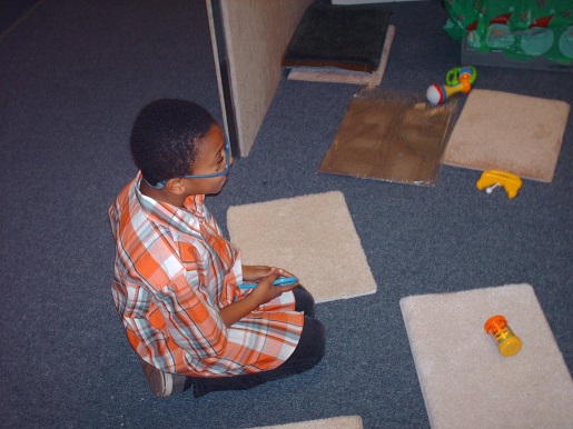 A boy playing with the sound makers